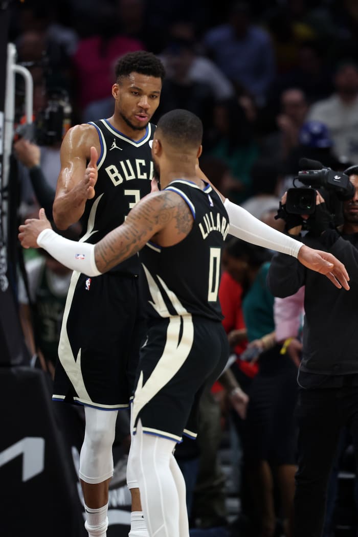 Milwaukee Bucks forward Giannis Antetokounmpo (34) celebrates with guard Damian Lillard (0) 